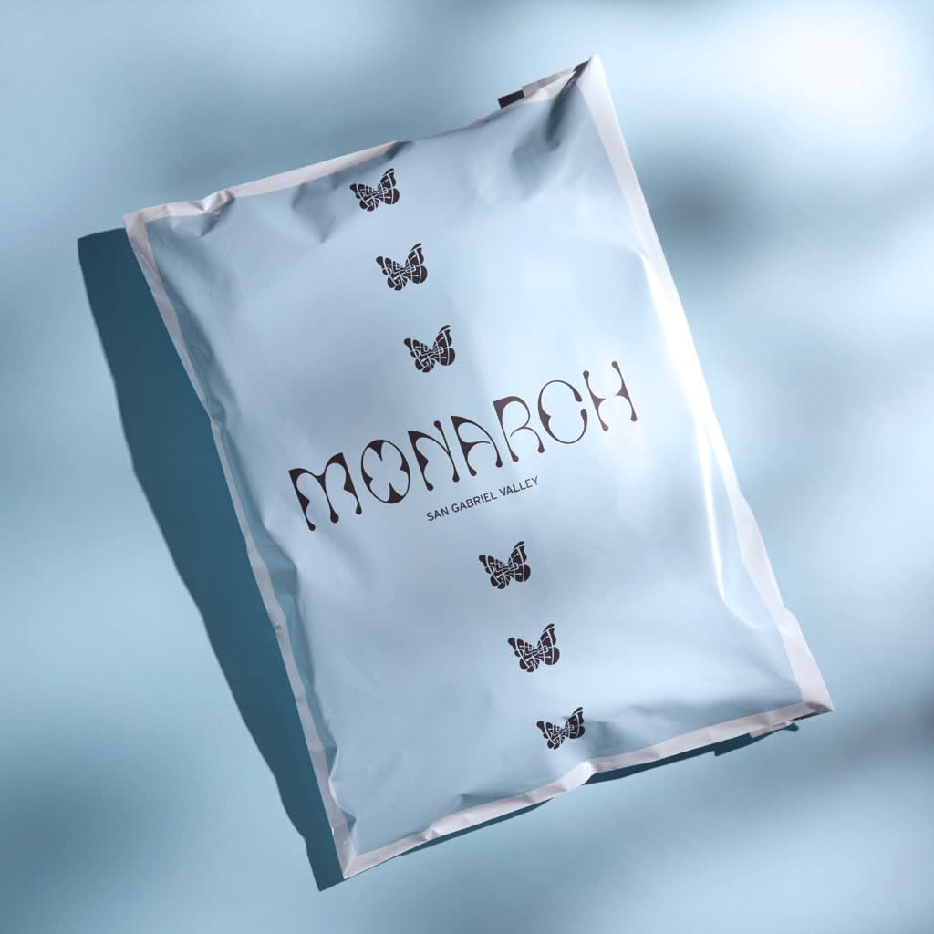 Blue and white branded mailer packaging with butterfly design.
