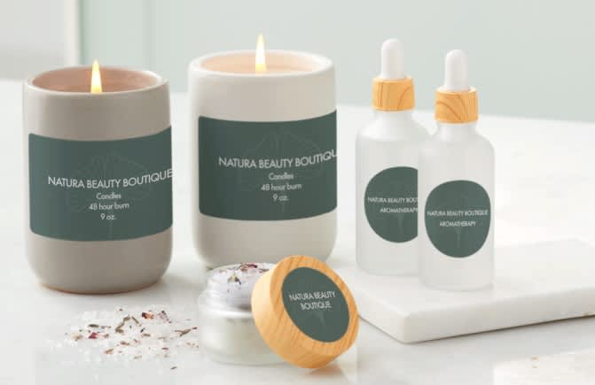A selection of candles and glass containers with minimalist dark green labels with simple white font.
