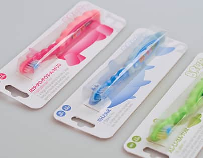 Three colourful children&rsquo;s toothbrushes in blister pack packaging with display cards on a light grey background.