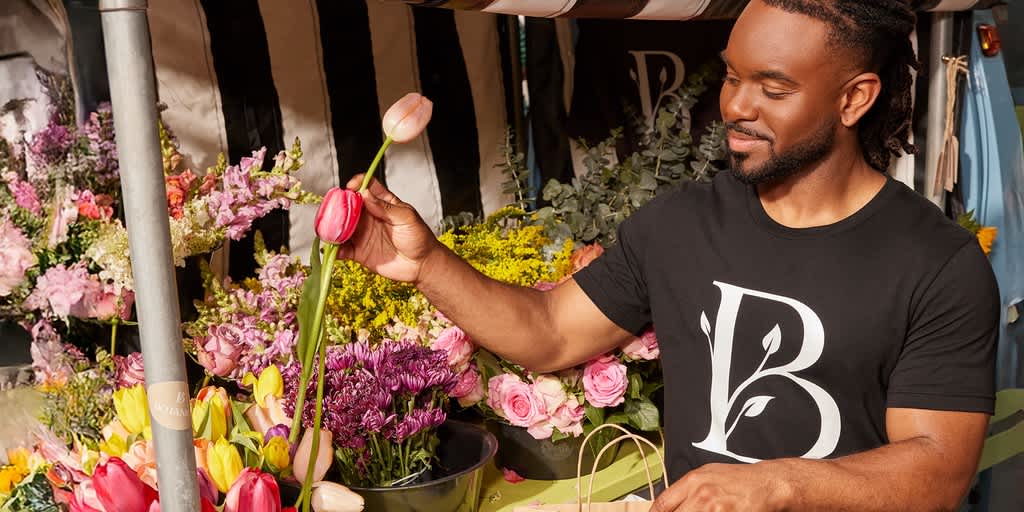 Florist wearing t-shirt with brand logo.