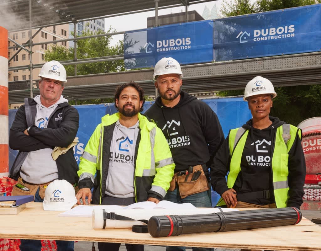 Construction workers wearing branded hoodies in brand colors with the brand logo.
