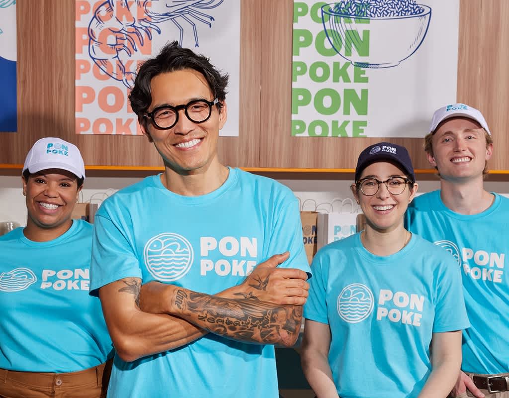 Poke shop business owner with three employees all wearing the same baby blue T-shirt with simple white logo and “Pon Poke” text.