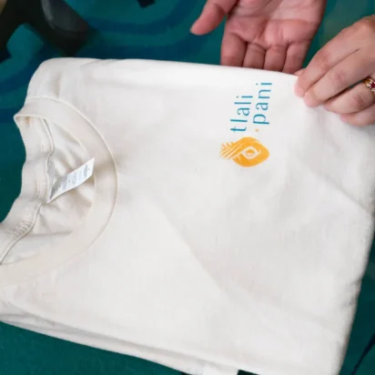 Hands holding white branded T-shirt