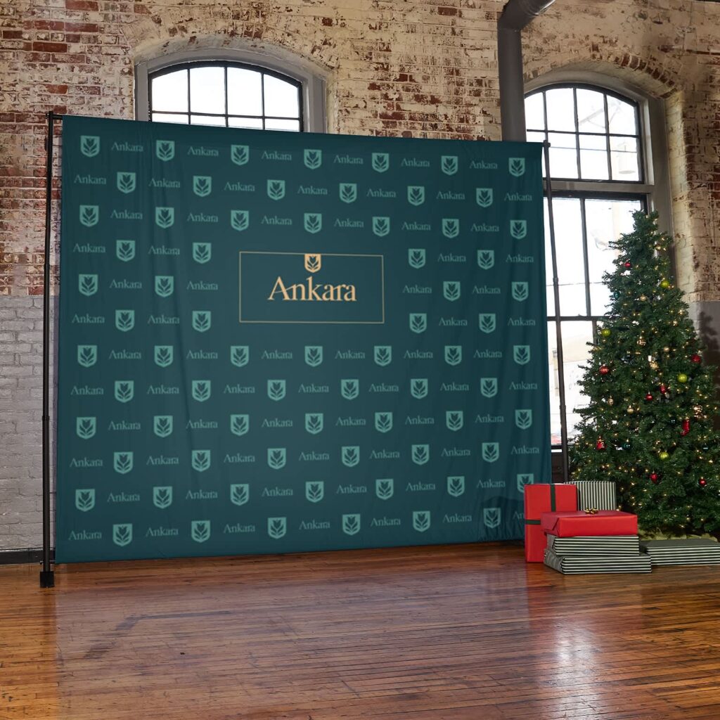 Branded step-and-repeat banner with a logo pattern, festive photo booth.