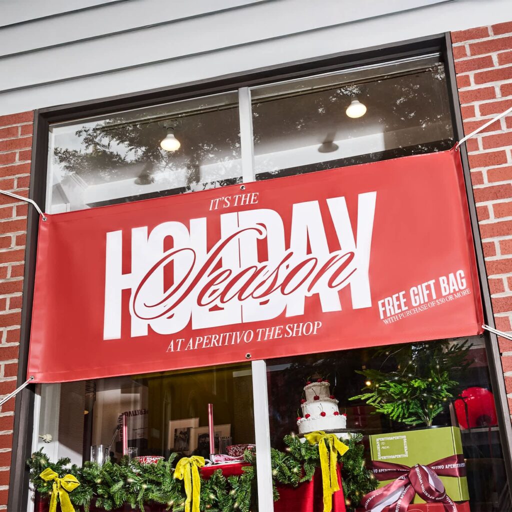 Holiday signage red vinyl banner advertising a free gift bag promotion.