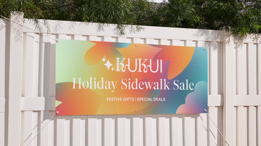 Large vinyl banner attached to white fence promoting holiday sidewalk sale.