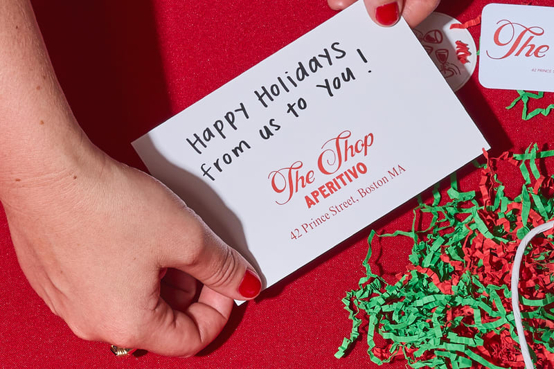 A minimalistic branded Christmas card from Aperitivo with a handwritten message &ldquo;Happy Holidays from us to you!&rdquo;