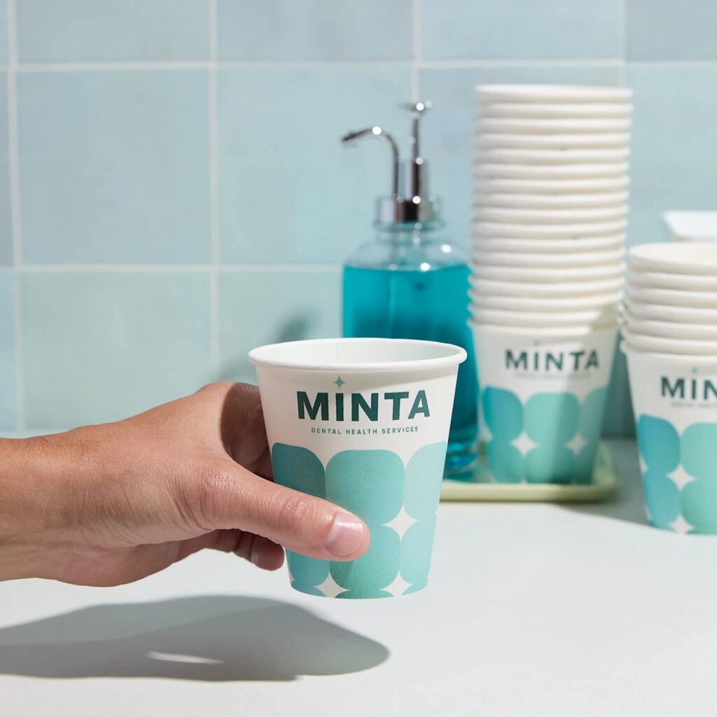 A hand holding a blue branded paper up for a dental brand.
