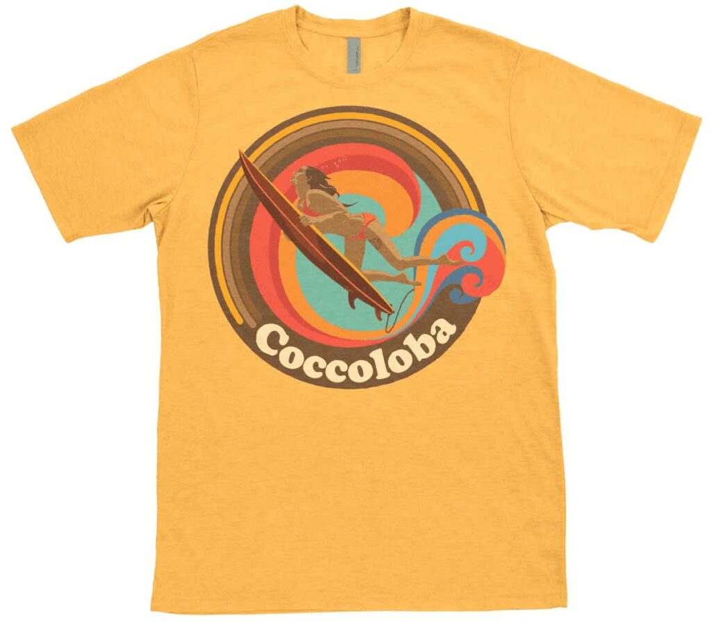 Yellow custom T-shirt featuring a retro-style surfing logo with colorful concentric circles, a surfer illustration and the word "Coccoloba."