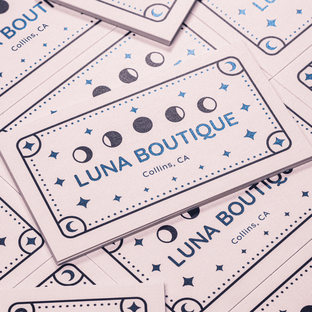 Business cards with moon icons and blue foil text “Luna Boutique”.