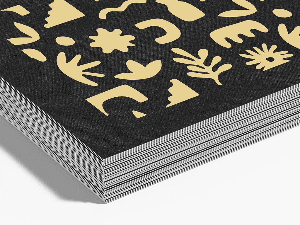 Close up of the corner of a stack of black business cards with yellow graphics.