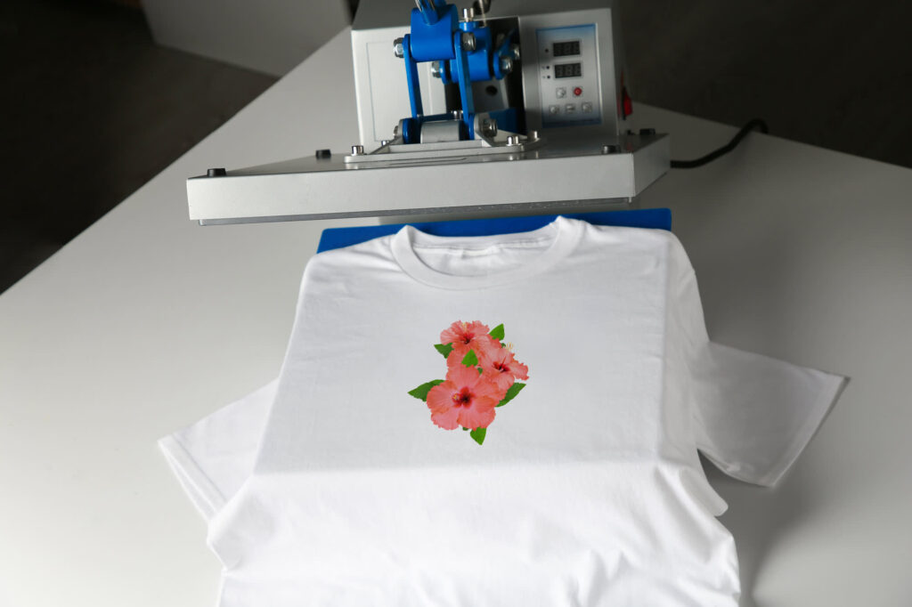 Heat press applying a design to a white T-shirt.]