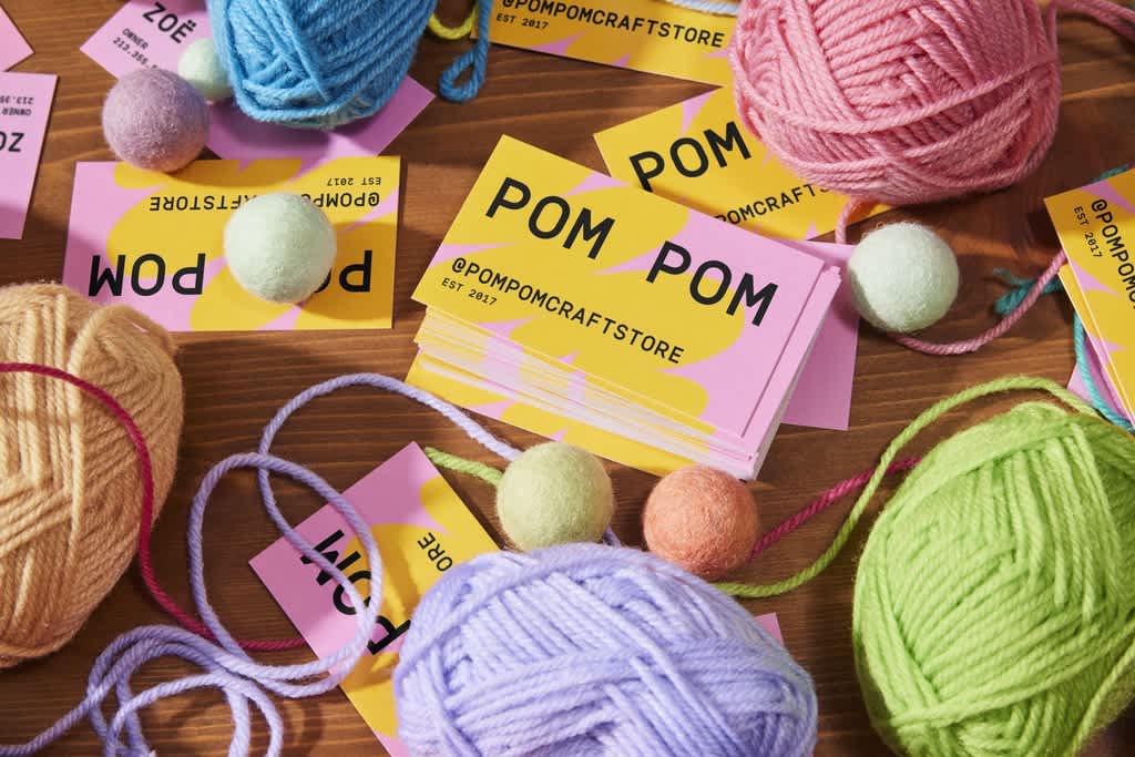 Pink and yellow business cards for a craft business with the social handle as the main contact information.