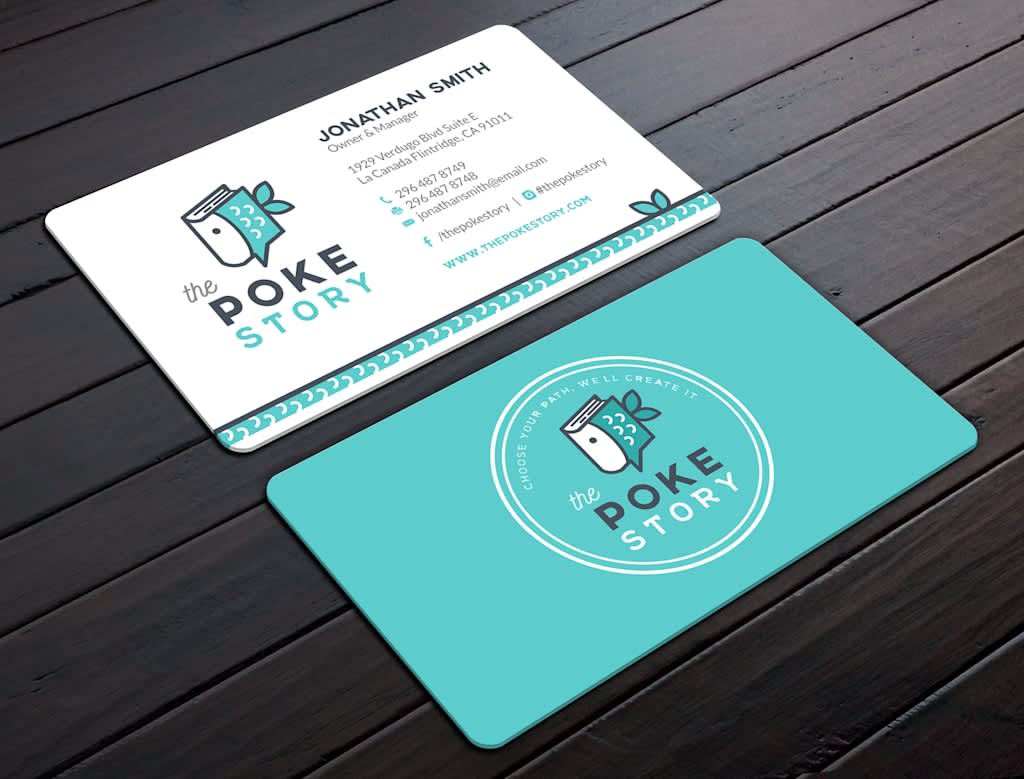 Two rounded business cards for The Poke Story displayed on a dark wooden surface.