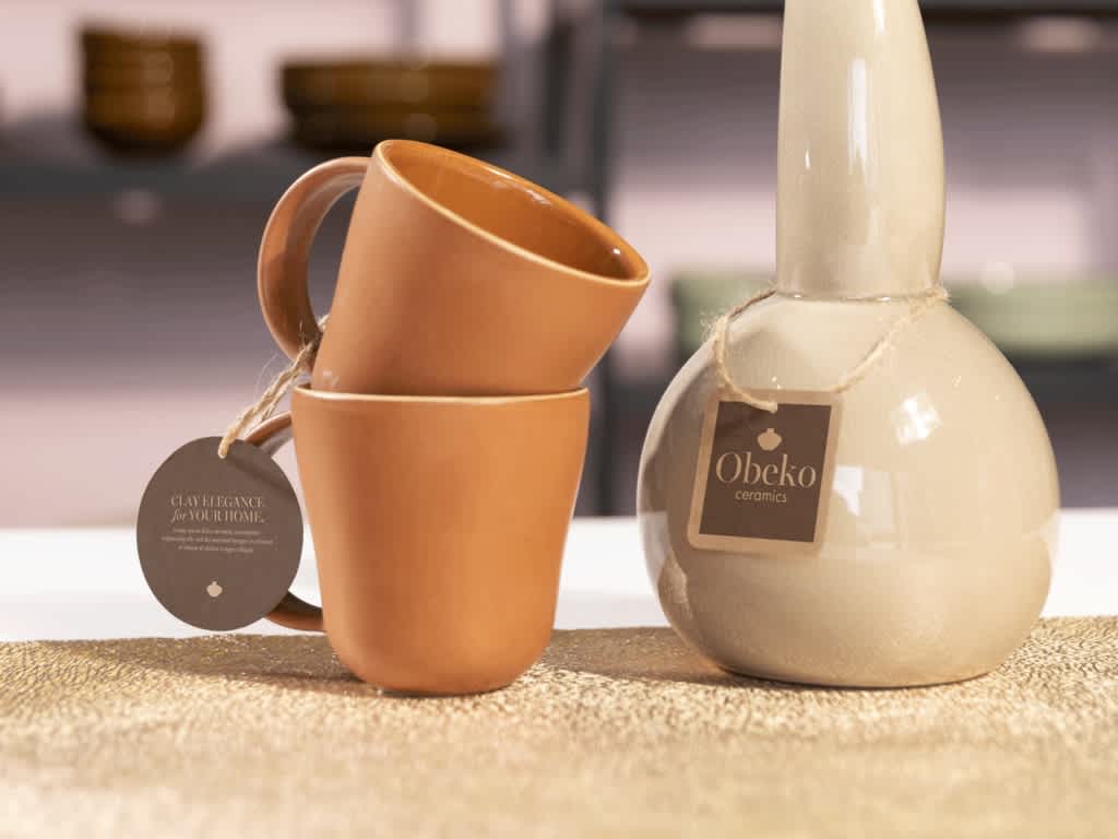 Ceramic mugs and bottles with cardboard hang tags.