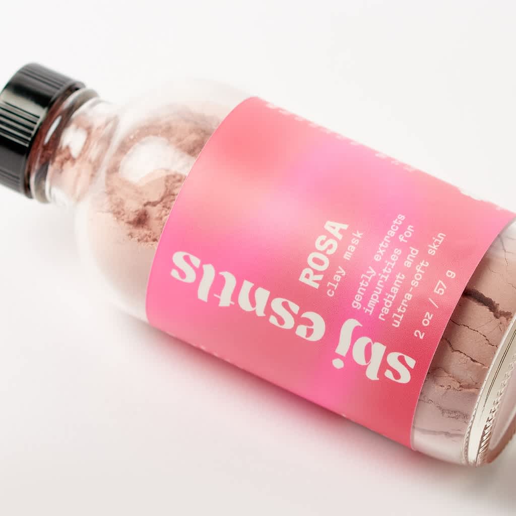 Skincare glass bottle for a clay mask with a simple pink product label design.