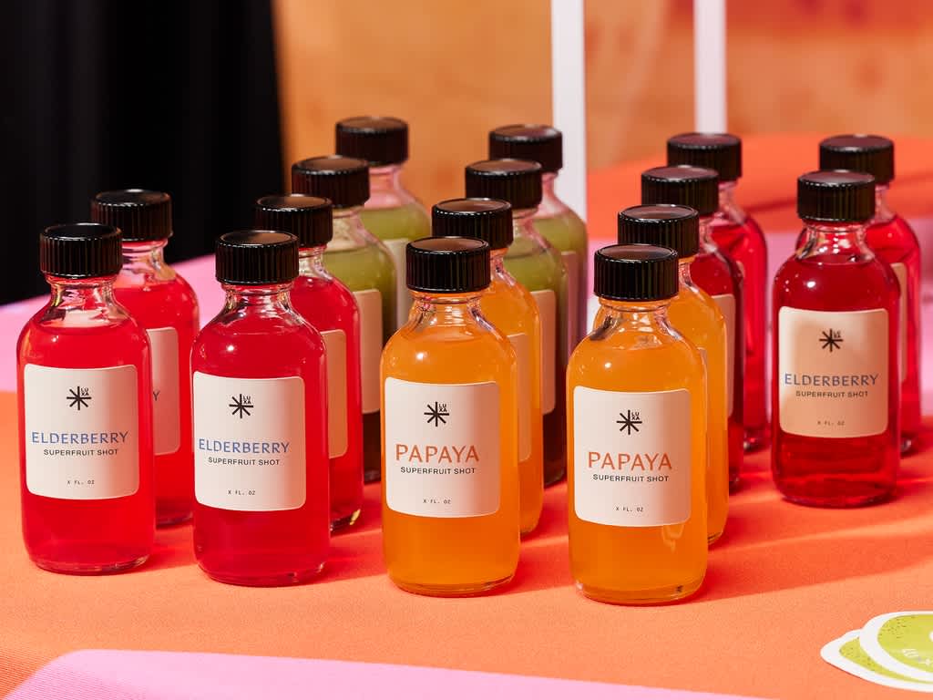 Small glass bottles containing health shots with simple white custom labels.