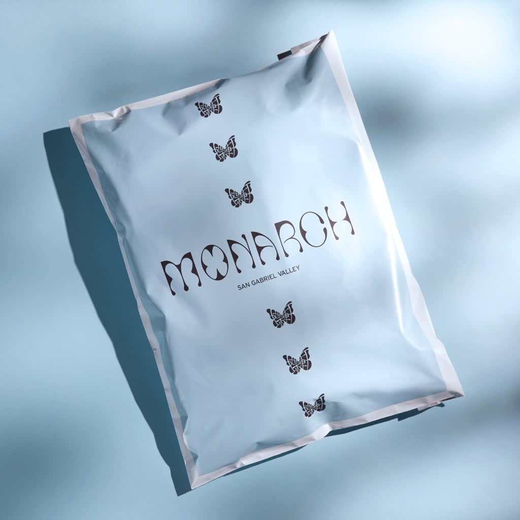 A blue mailer bag with black logo and branding.