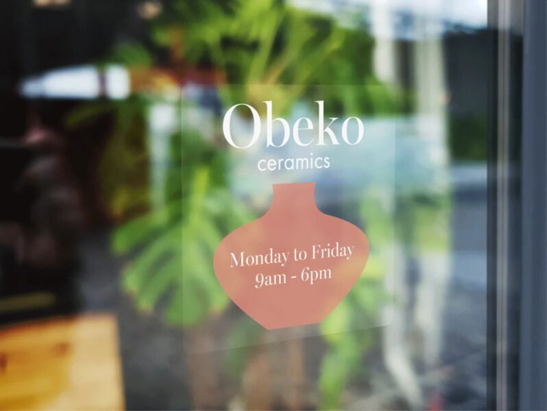 Window decal sign showing ceramics shops business hours.