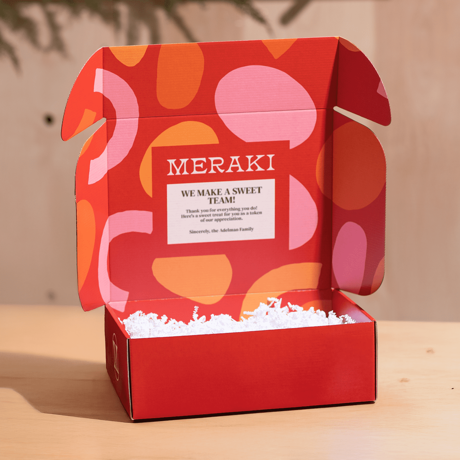 Red mailer box with lid open displaying interior top lid colorful design and message