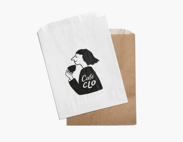 White and brown paper takeaway bags with Caf&eacute; Clo logo printed on the front.