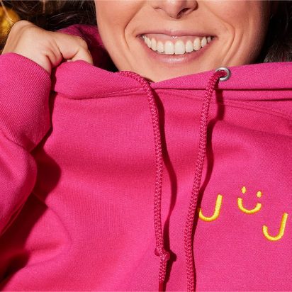 Barbiecore-Trend: eine Frau in einem pinkfarbenen Kapuzenpulli