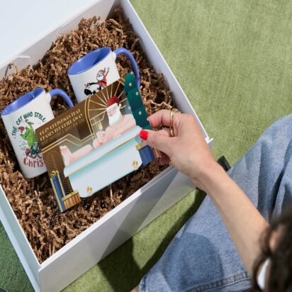 Hand opening gift basket to see Christmas card