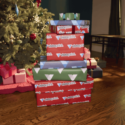 Stacked holiday gift packages with VistaPrint wrapping under a Christmas tree – perfect example of festive branding for small business holiday marketing tips.