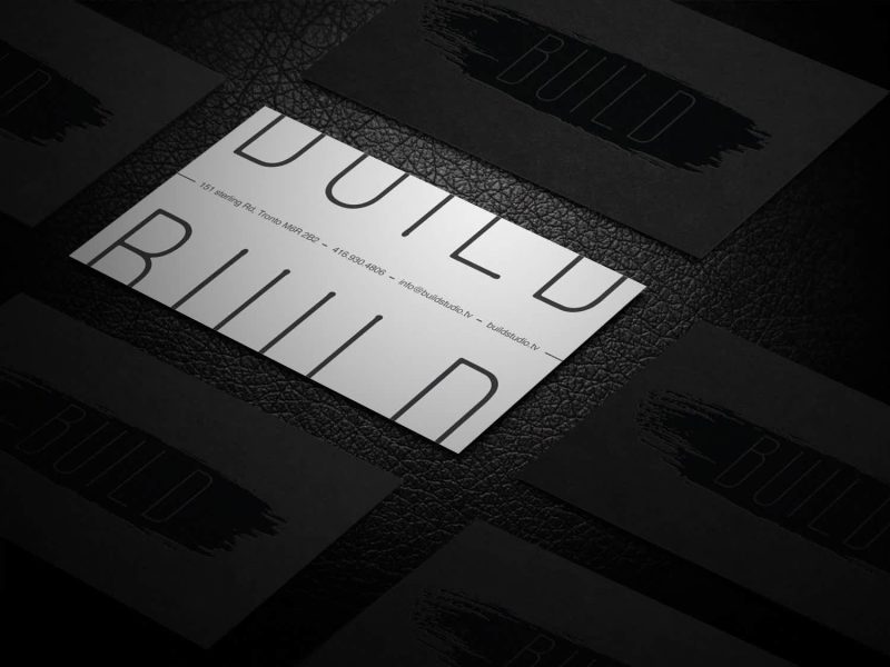 White business card with black text off the edge on top and bottom