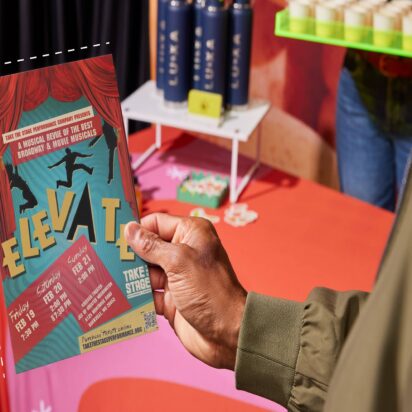Flyer coloré pour un spectacle, avec en arrière-plan des objets personnalisés comme des gobelets en papier, des nappes et des bouteilles.