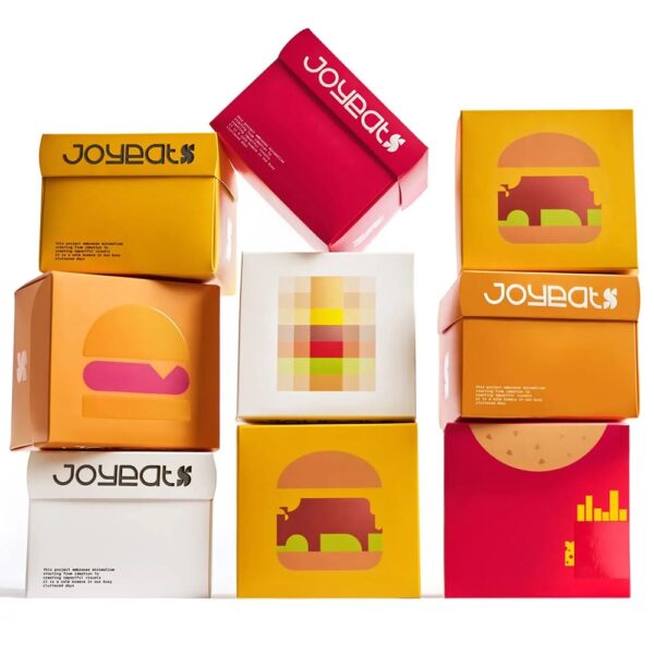 Bo&icirc;tes d&rsquo;emballage individuelles pour hamburgers pr&eacute;sentant des images pixelis&eacute;es de burgers et des repr&eacute;sentations de burgers cr&eacute;&eacute;es gr&acirc;ce &agrave; une utilisation ing&eacute;nieuse de l&rsquo;espace blanc.