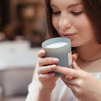 Woman smelling a candle in a candle shop